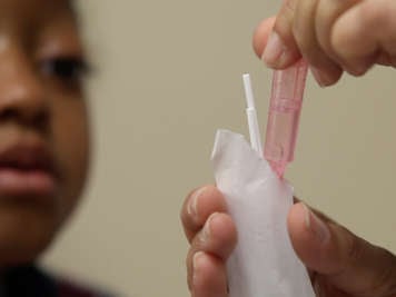 Dripping saline into a small package of cotton swabs.